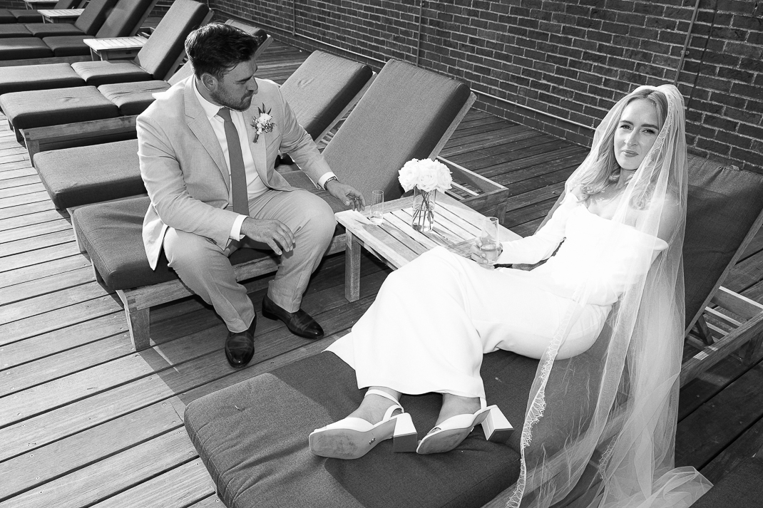 NATHALIE DELENTE PHOTOGRAPHY-201 candid image of bride and groom on sunloungers on their wedding day, in Essex wedding venue