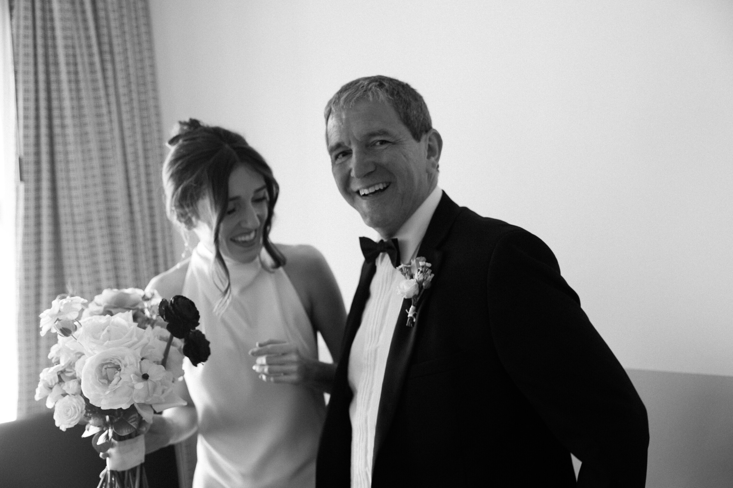 modern editorial wedding photography London Essex NATHALIE DELENTE PHOTOGRAPHY moment between bride and father - both laughing with father looking into the camera